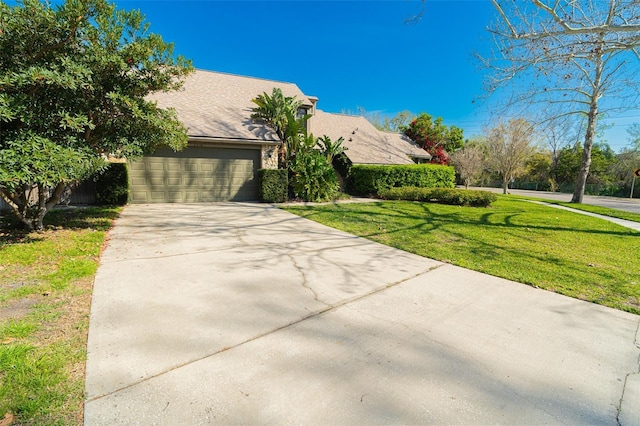 view of front of home featuring driveway, a garage, and a front lawn