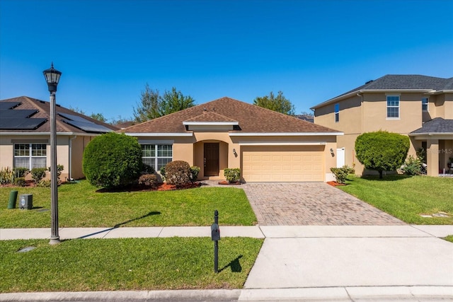 ranch-style home featuring a front yard, decorative driveway, a garage, and stucco siding