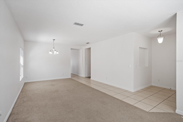 unfurnished room with light tile patterned floors, visible vents, light carpet, and a chandelier