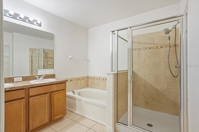 bathroom with a garden tub, double vanity, a sink, a shower stall, and tile patterned floors