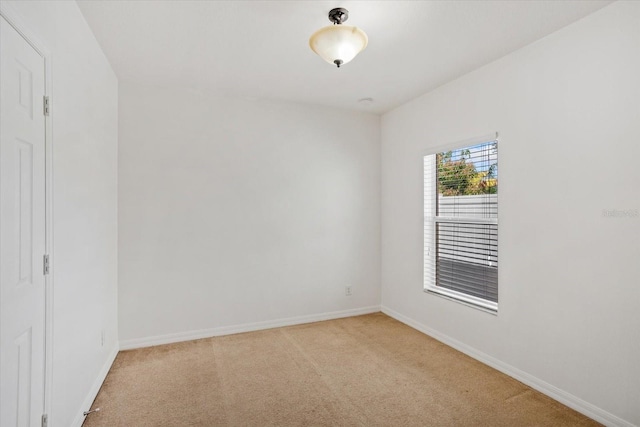 empty room with light colored carpet and baseboards