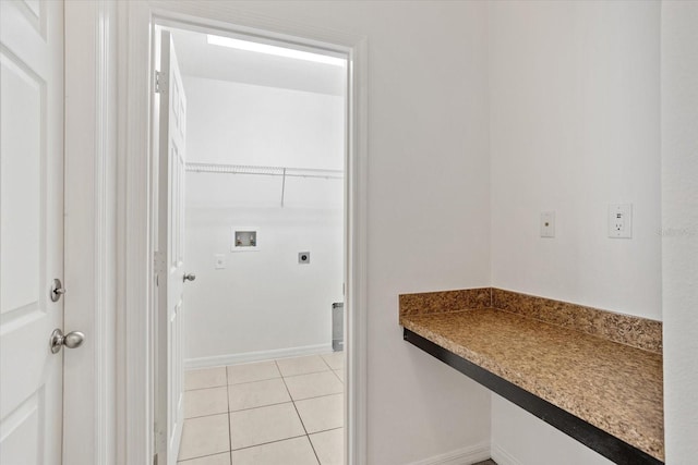 laundry area featuring electric dryer hookup, washer hookup, light tile patterned flooring, baseboards, and laundry area