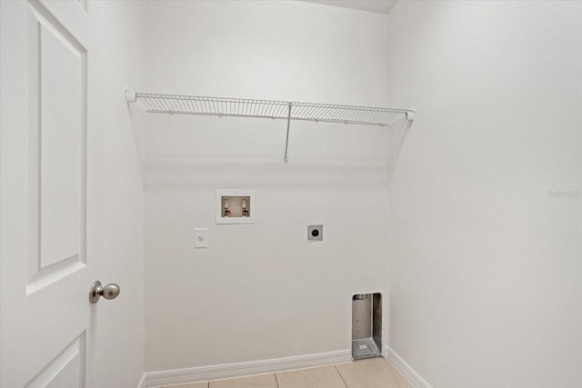 washroom featuring electric dryer hookup, washer hookup, light tile patterned flooring, baseboards, and laundry area