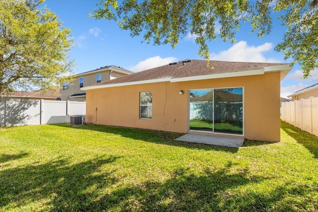 back of property featuring central AC unit, a lawn, a fenced backyard, and stucco siding