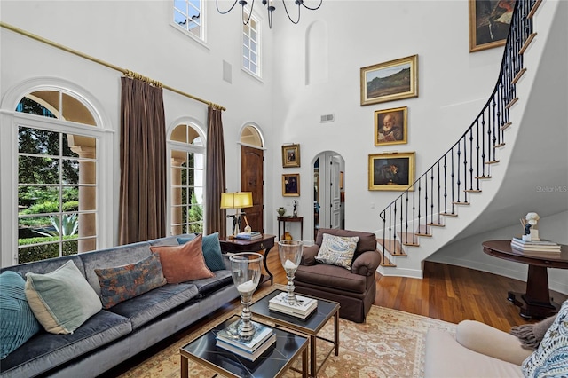 living room featuring hardwood / wood-style flooring and a towering ceiling