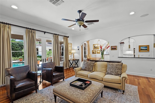 living room with ceiling fan, ornamental molding, and wood-type flooring