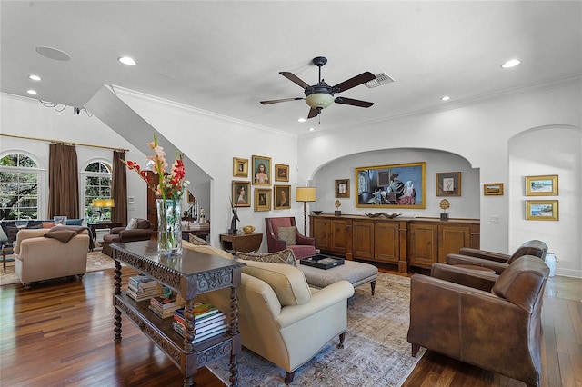 living room with crown molding, dark wood-type flooring, and ceiling fan