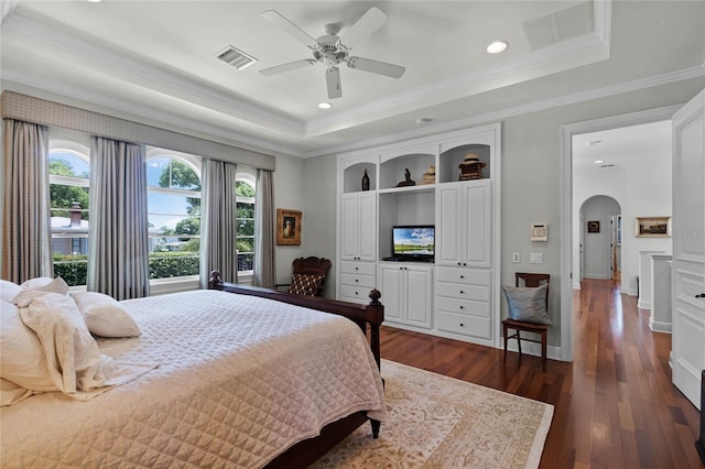 bedroom with crown molding, ceiling fan, a tray ceiling, and dark hardwood / wood-style flooring