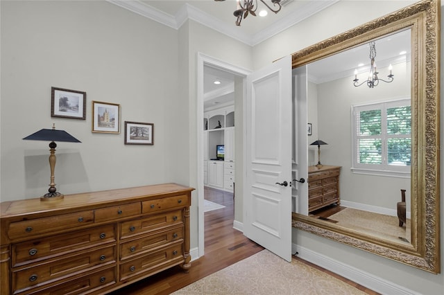 interior space featuring a notable chandelier, hardwood / wood-style flooring, and ornamental molding