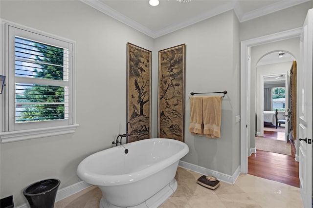 bathroom with crown molding and a bathtub