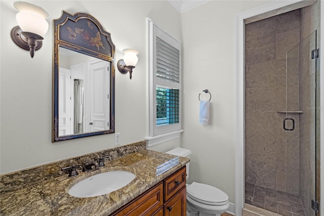 bathroom featuring an enclosed shower, vanity, and toilet