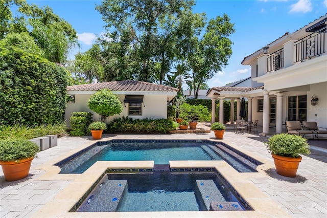 view of pool with an in ground hot tub, ceiling fan, and a patio area