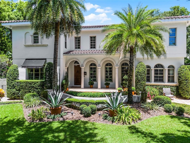 mediterranean / spanish home with a front lawn