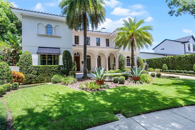 mediterranean / spanish home featuring a front lawn