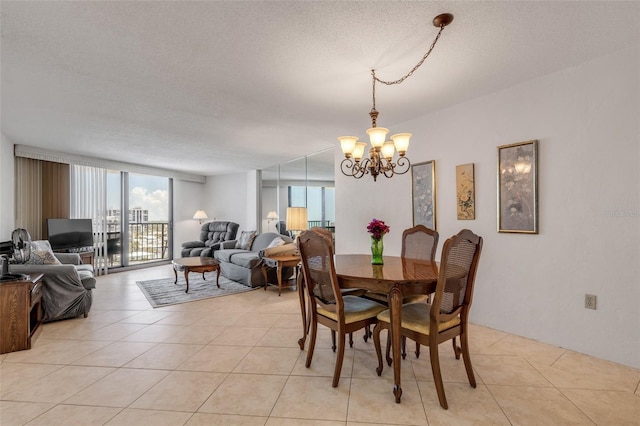 dining area with light tile patterned floors, a notable chandelier, and a textured ceiling