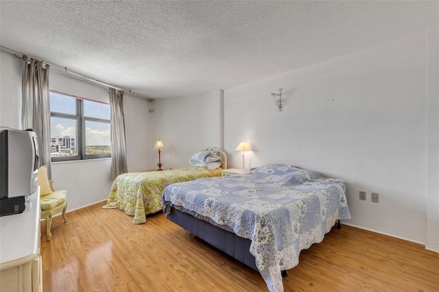 bedroom featuring hardwood / wood-style flooring and a textured ceiling