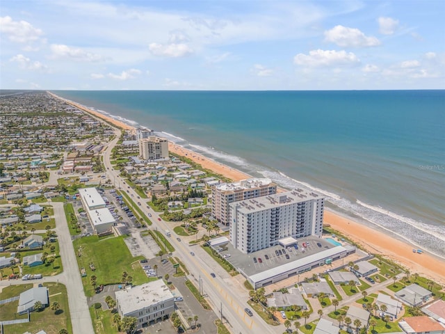 birds eye view of property with a water view and a beach view