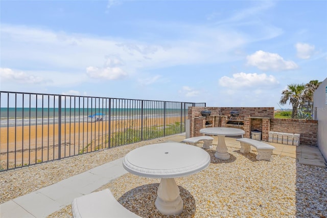 view of patio / terrace featuring a beach view and a water view