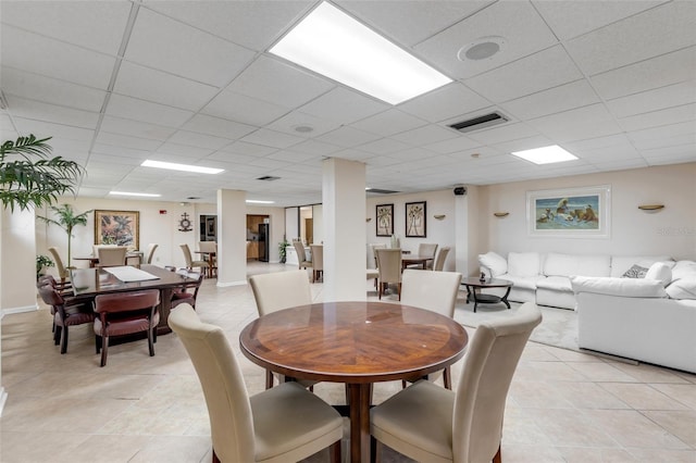 tiled dining room featuring a drop ceiling