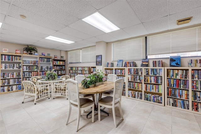 tiled dining space with a paneled ceiling