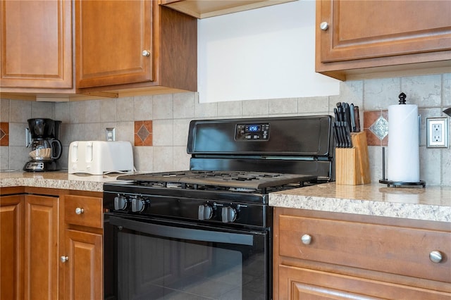 kitchen with black range with gas stovetop and decorative backsplash