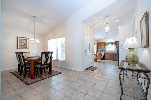 tiled dining space featuring sink and vaulted ceiling