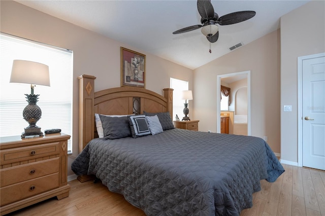 bedroom with ceiling fan, lofted ceiling, light hardwood / wood-style floors, and ensuite bath