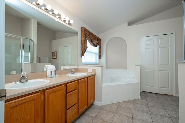 bathroom with tile patterned floors, vanity, separate shower and tub, and vaulted ceiling