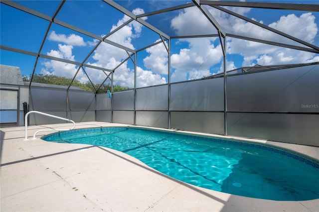 view of swimming pool with a patio area and glass enclosure