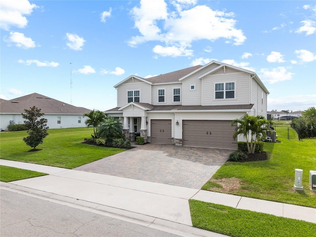 view of front of home featuring decorative driveway, an attached garage, and a front lawn