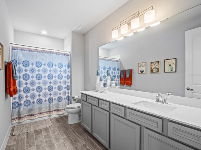 full bathroom with wood finish floors, vanity, and toilet