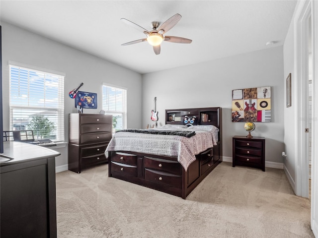 bedroom with baseboards, a ceiling fan, and light colored carpet