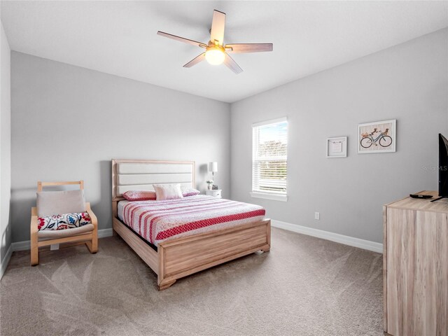 carpeted bedroom with ceiling fan and baseboards