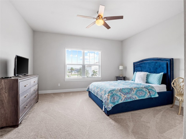 bedroom featuring baseboards, a ceiling fan, and light colored carpet