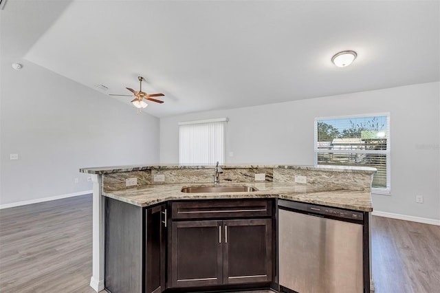 kitchen featuring dark wood-style flooring, a sink, dark brown cabinets, light stone countertops, and dishwasher