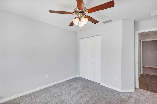 unfurnished bedroom featuring a closet, carpet flooring, visible vents, and baseboards