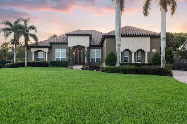 mediterranean / spanish house featuring a lawn