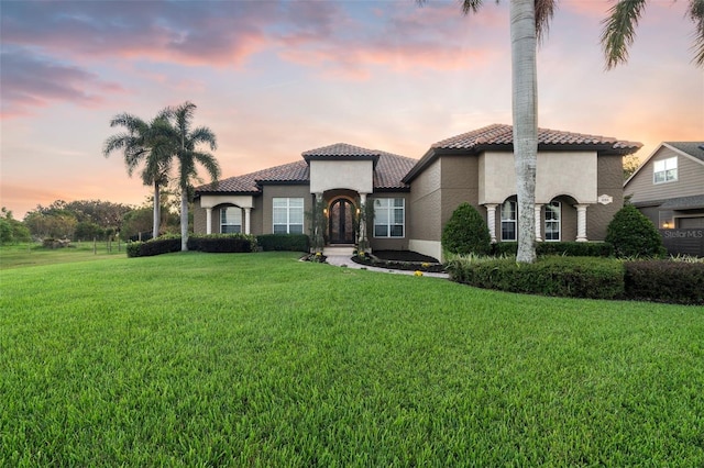 mediterranean / spanish home with a lawn