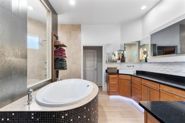 bathroom featuring tasteful backsplash, vanity, and independent shower and bath