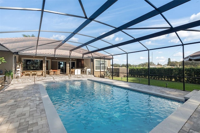 view of swimming pool with a bar, exterior kitchen, a patio area, and glass enclosure