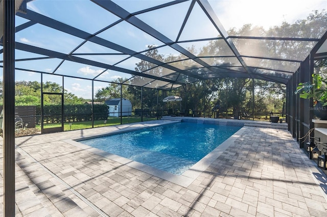 view of pool with a lanai, a shed, and a patio