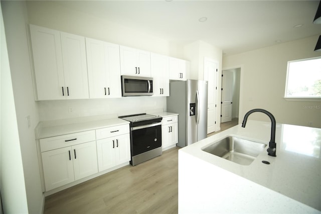 kitchen with sink, stainless steel appliances, and white cabinets