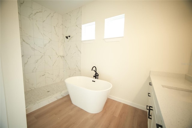 bathroom with wood-type flooring, separate shower and tub, and vanity