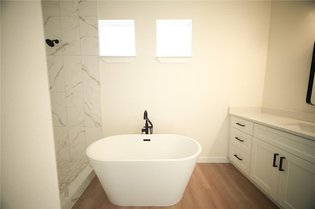 bathroom featuring vanity, a bath, and hardwood / wood-style flooring