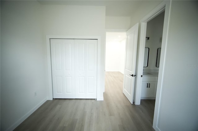 unfurnished bedroom featuring light wood-type flooring and a closet