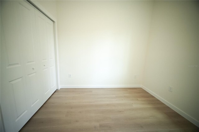 unfurnished bedroom with light hardwood / wood-style floors and a closet