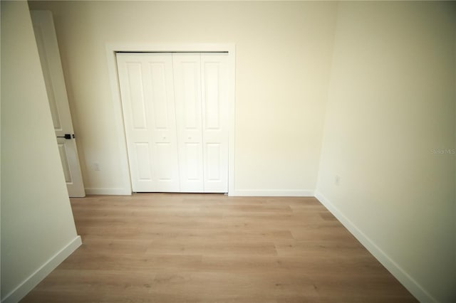 unfurnished bedroom featuring light hardwood / wood-style floors and a closet