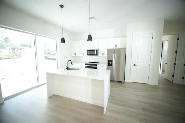 kitchen featuring sink, a center island with sink, hanging light fixtures, stainless steel appliances, and white cabinets