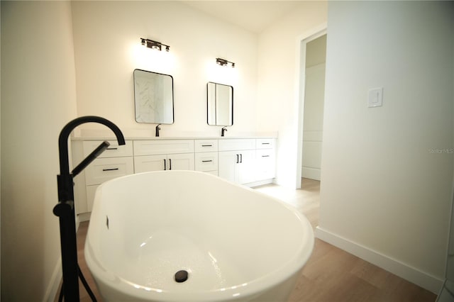 bathroom featuring vanity, hardwood / wood-style floors, and a tub