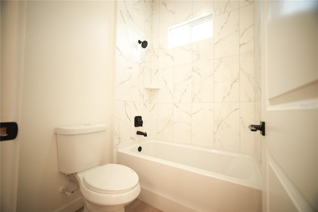 bathroom with tiled shower / bath combo and toilet